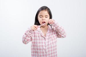 little girl Asia brushing teeth happily white background photo