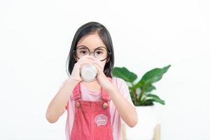 niño asia chica bebe leche con un vaso foto