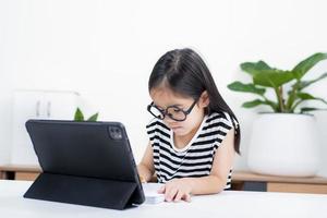 niña estudiante asiática guau emocionada en videollamada aprendiendo a estudiar clase en línea o persona aprende de la escuela en casa con tableta