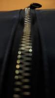 A closeup shot of the zipper on the luxury black bag photo