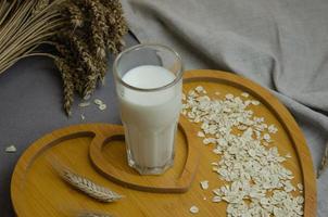 vegetable milk from flakes in a glass on a wooden tray. Vegetarian dietary food photo