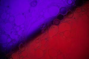 vista superior movimiento de burbujas en el líquido. fondo multicolor de la superficie del aceite. fantástica estructura de burbujas de colores. imagen artística colorida de gota de aceite flotando en el agua. foto