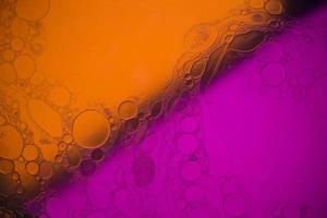 Top view movement of bubbles in the liquid. Oil surface multicolored background. Fantastic structure of colorful bubbles. Colorful artistic image of oil drop floating on the water. photo