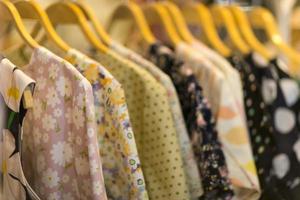 Clothes that are arranged on shelves and hangers photo