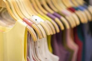 Clothes that are arranged on shelves and hangers photo