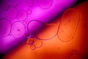 Top view movement of bubbles in the liquid. Oil surface multicolored background. Fantastic structure of colorful bubbles. Colorful artistic image of oil drop floating on the water. photo