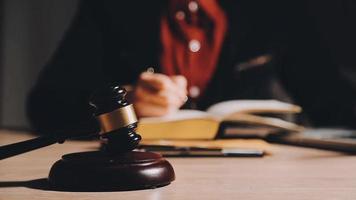 Business and lawyers discussing contract papers with brass scale on desk in office. Law, legal services, advice, justice and law concept picture with film grain effect video