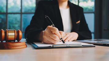 zaken en advocaten bespreken contractpapieren met koperen schaal op bureau in kantoor. wet, juridische diensten, advies, rechtvaardigheid en wet concept foto met film grain effect video