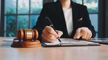 Business and lawyers discussing contract papers with brass scale on desk in office. Law, legal services, advice, justice and law concept picture with film grain effect video