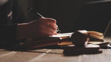 Business and lawyers discussing contract papers with brass scale on desk in office. Law, legal services, advice, justice and law concept picture with film grain effect video