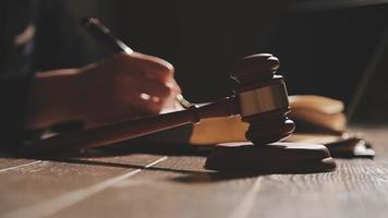 Business and lawyers discussing contract papers with brass scale on desk in office. Law, legal services, advice, justice and law concept picture with film grain effect video