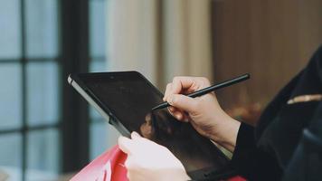 Image of two young businessmen using touchpad at meeting video