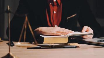 Business and lawyers discussing contract papers with brass scale on desk in office. Law, legal services, advice, justice and law concept picture with film grain effect video
