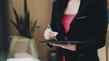 Image of two young businessmen using touchpad at meeting video