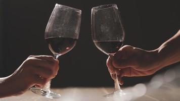 impostato di mani Tenere rosso vino bicchiere isolato su nero sfondo. video