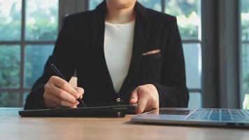 groupe d'hommes d'affaires utilisant une tablette numérique ensemble devant les fenêtres d'un immeuble de bureaux donnant sur la ville video