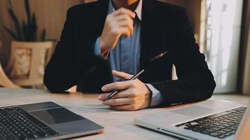 Image of two young businessmen using touchpad at meeting video