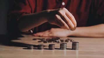 las mujeres de negocios ponen dinero en la pila de monedas y muchos billetes de banco en el cargo, ahorran dinero para el futuro y la jubilación. video