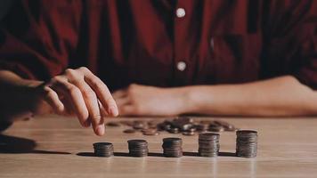 las mujeres de negocios ponen dinero en la pila de monedas y muchos billetes de banco en el cargo, ahorran dinero para el futuro y la jubilación. video