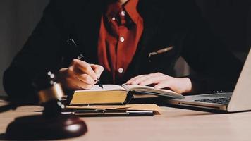 Business and lawyers discussing contract papers with brass scale on desk in office. Law, legal services, advice, justice and law concept picture with film grain effect video