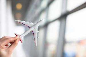 Close up hand holding an airplane model at airport photo