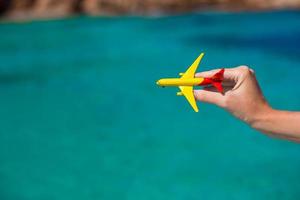 Small homemade plane in hand on background of the sea photo