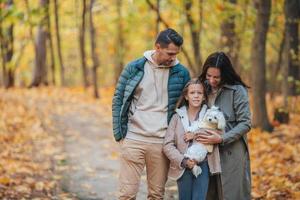 Portrait of happy family of three in autumn day photo