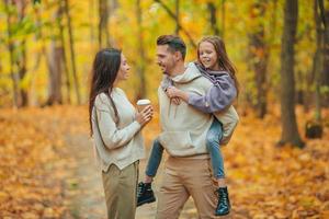 Portrait of happy family of three in autumn day photo