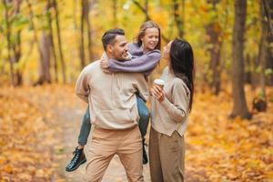 Portrait of happy family of three in autumn day photo