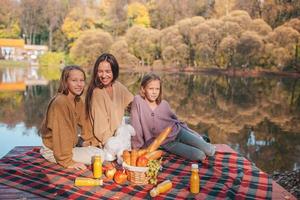 Happy family on a picnic in the park at autumn photo