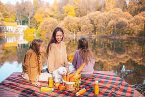 Happy family on a picnic in the park at autumn photo