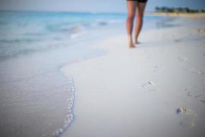 Human footprints on white sand beach photo