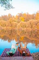 Beautiful family at autumn warm day near lake photo