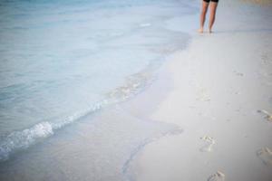 Human footprints on white sand beach photo