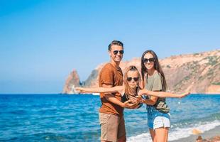 Young family on white beach during summer vacation photo