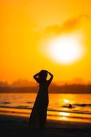 mujer tendida en la playa disfrutando de las vacaciones de verano foto