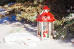 Decorative Christmas lantern near fir branch in snow winter day photo