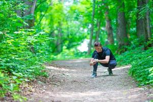 Runner looking at smart watch heart rate monitor having break while running photo