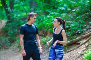 Jogging active couple resting after running outdoors in forest photo