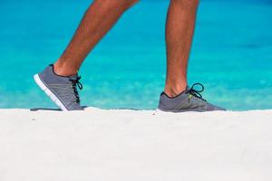 Young male runner getting ready to start on white beach photo