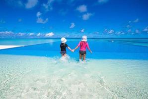 Adorable little girls playing in outdoor swimming pool photo