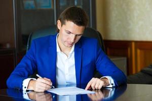 hombre de negocios firmando un contrato en una gran oficina foto