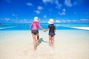 Adorable little girls playing in outdoor swimming pool photo