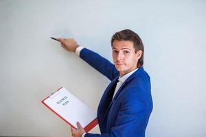 Young businessman with business plan and financial documents in his office photo
