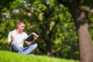 Clever man in park outside write down his thoughts in a notebook photo
