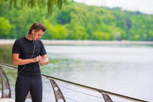 Runner looking at smart watch heart rate monitor having break while running photo