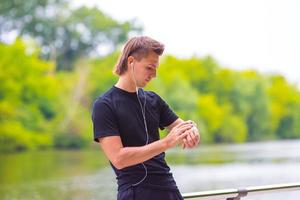 Runner looking at smart watch heart rate monitor having break while running photo