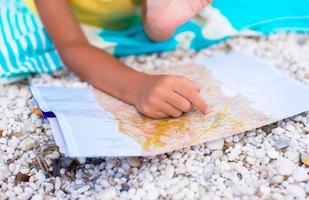 adorable niña con mapa de isla en playa tropical foto