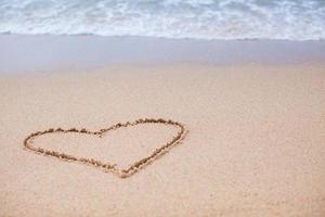 Heart painted in the sand on a tropical beach photo