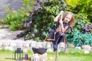 Adorable amasing little girl wearing witch costume on Halloween. Trick or treat. photo